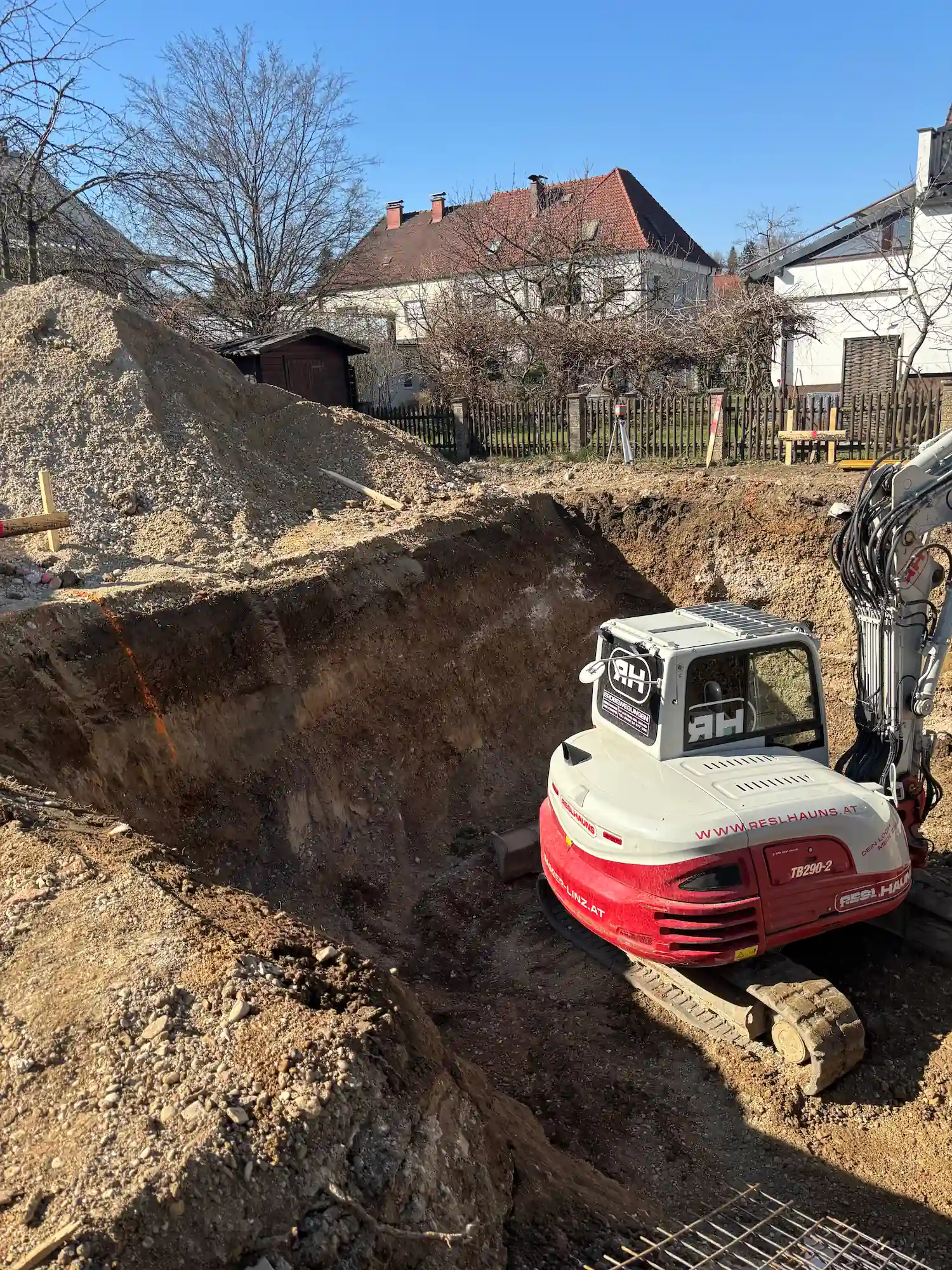 Bagger der Firma Reslhauns GmbH aus Linz beim Aushub eines Kellerlochs für ein Einfamilienhaus